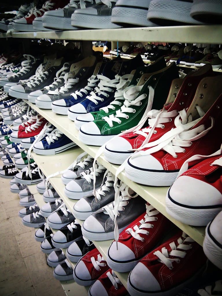 Shelves of canvas high-top sneakers in black, white, red, green and navy.